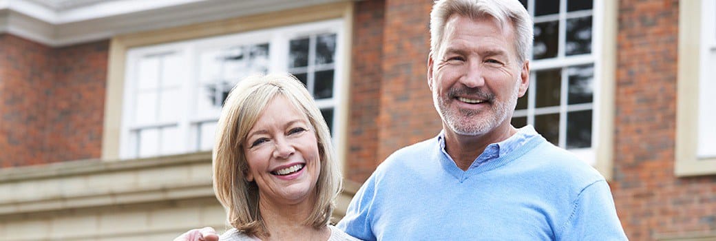 Smiling, happy couple with dental implants in Greensboro