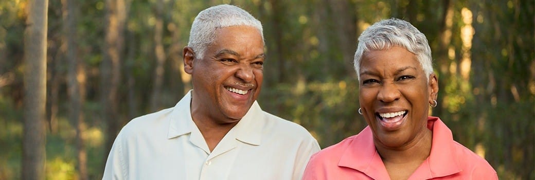 a man and a woman smiling with implant retained dentures